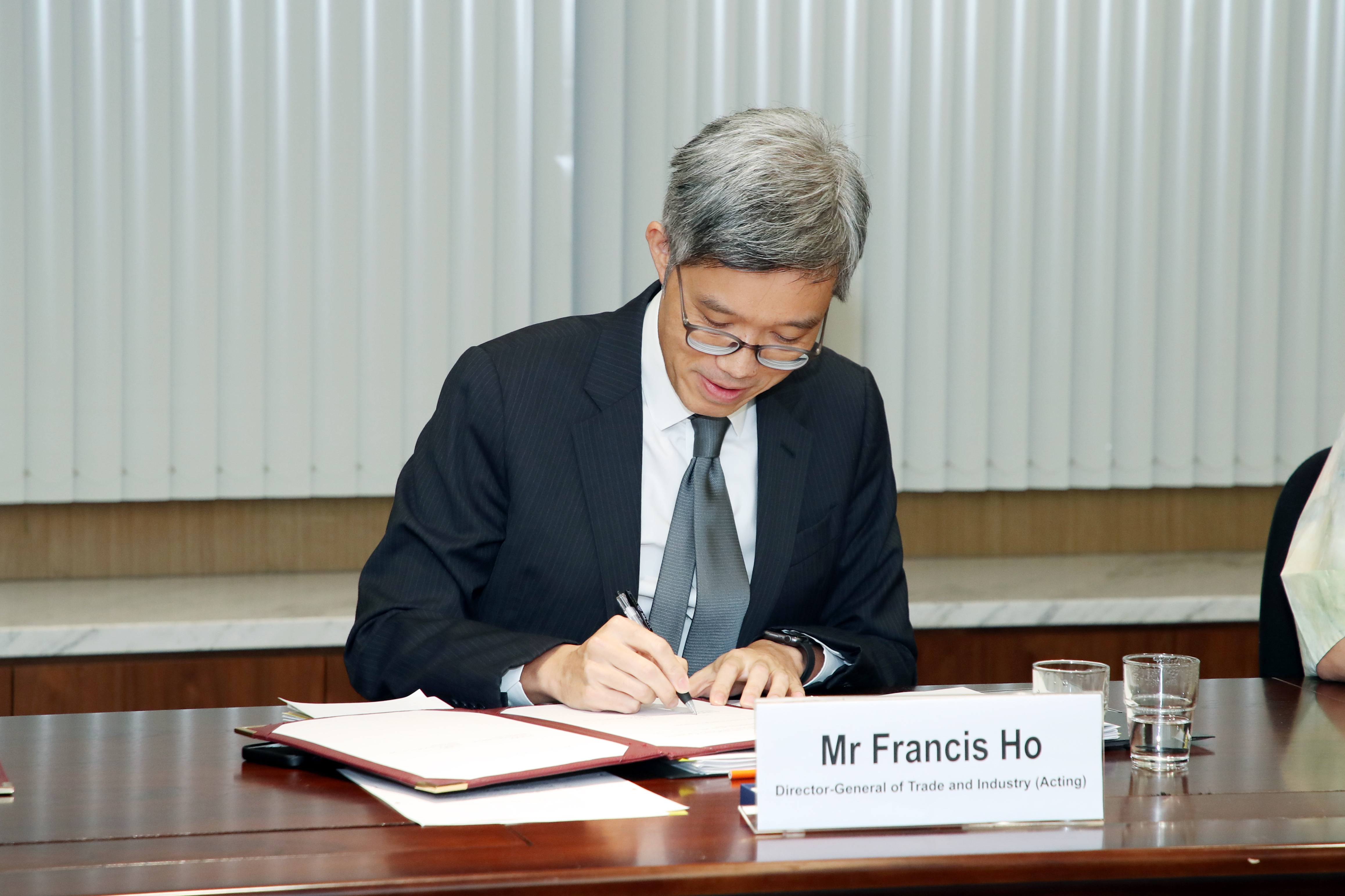 Hong Kong and New Zealand signed three implementing arrangements at the video-conference meeting of the Joint Commission under the Closer Economic Partnership Agreement today (May 5) to facilitate the ongoing co-operation and communication in the areas of rules of origin, sanitary and phytosanitary measures, and government procurement. Picture shows the Acting Director-General of Trade and Industry, Mr Francis Ho, signing the implementing arrangements.